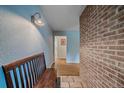 Inviting entryway with a wooden bench, brick accent wall, and hardwood floors at 4320 Teller St, Wheat Ridge, CO 80033