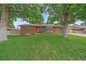 Charming brick home with a well-manicured lawn and mature trees at 4320 Teller St, Wheat Ridge, CO 80033