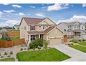 Inviting two-story home with a manicured lawn, showcasing a large garage and charming curb appeal at 2510 E 160Th Pl, Thornton, CO 80602