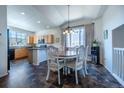 Eating nook with a wood table, chandelier, and large windows provides abundant natural light at 5659 Viewpoint Ave, Firestone, CO 80504