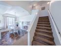 Bright entryway featuring a staircase, high ceilings, and an adjacent dining area with a round table at 5659 Viewpoint Ave, Firestone, CO 80504