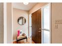 Cozy entryway with hardwood floors, a round mirror, and a stylish chair at 8370 E Princeton Ave, Denver, CO 80237