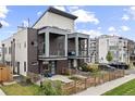 Modern home featuring a brick facade, balconies, and fenced front yard with patio furniture at 1302 N Stuart St, Denver, CO 80204