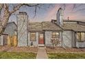 Charming home featuring a red front door, neutral siding, mature trees, and low-maintenance landscaping at 10731 W 63Rd Ave # A, Arvada, CO 80004