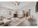 Bright living room with fireplace, vaulted ceiling, modern furniture, and access to patio at 10731 W 63Rd Ave # A, Arvada, CO 80004