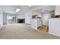 Inviting living space with stone fireplace, balcony access, and updated kitchen featuring white cabinets and modern appliances at 910 S Walden St # 201, Aurora, CO 80017