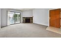 Spacious living room with a stone fireplace and sliding glass doors to a balcony, flooding the room with natural light at 910 S Walden St # 201, Aurora, CO 80017
