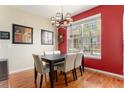 Bright dining room featuring hardwood floors, a modern chandelier, and a large window view at 11962 W Long Cir # 103, Littleton, CO 80127