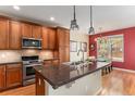 Well-equipped kitchen with stainless steel appliances, granite countertops, and a dining area at 11962 W Long Cir # 103, Littleton, CO 80127