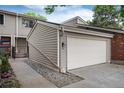 Two-car garage featuring neutral siding and a well-manicured, landscaped entrance, with fresh rocks and manicured shrubs at 7925 W Layton Ave # 605, Littleton, CO 80123