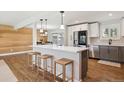 Spacious kitchen features a central island, white cabinets, stainless appliances and wood floors throughout at 8242 E Briarwood Pl, Centennial, CO 80112