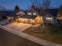 Aerial view of a well-maintained two-story home with a three-car garage and landscaped yard at 8220 S Brentwood St, Littleton, CO 80128