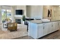 Well-lit living room open to kitchen with fireplace, stylish chairs and decor at 9471 Ashbury Cir # 202, Parker, CO 80134
