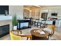 Bright living room with a modern fireplace and stylish decor open to kitchen with granite countertops and breakfast bar seating at 9471 Ashbury Cir # 202, Parker, CO 80134