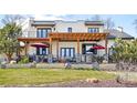Beautiful backyard with a covered patio, stone accents, and a well-maintained lawn at 3930 S Pinehurst Cir, Denver, CO 80235