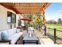 Charming outdoor patio with comfortable seating, a fire pit, and a pergola, perfect for entertaining at 3930 S Pinehurst Cir, Denver, CO 80235