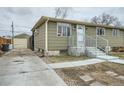 Charming home featuring a quaint front yard, long driveway, and single car detached garage at 7770 Kenwood St, Commerce City, CO 80022