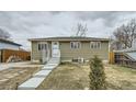 View of the home's exterior, with a well-maintained lawn and freshly painted facade at 7770 Kenwood St, Commerce City, CO 80022