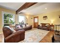 Bright living room with an area rug, wood beam, and ample natural light at 10381 Hondah Dr, Littleton, CO 80127