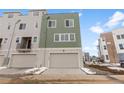 Townhome featuring a two-car garage and gray siding at 14283 Currant St, Broomfield, CO 80020