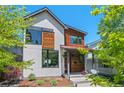 Modern two-story home featuring a red front door and a mix of white siding and stained wood accents at 3425 W Moncrieff Pl, Denver, CO 80211