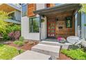 Close up of modern two-story home featuring a red front door and stained wood accents at 3425 W Moncrieff Pl, Denver, CO 80211