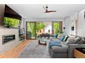 Open living room with large sectional couch, built-in shelving, fireplace, and sliding glass doors to outdoor space at 3425 W Moncrieff Pl, Denver, CO 80211