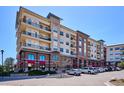 Multi-story condo building featuring balconies and a commercial space with retail and restaurant tenants at 10111 Inverness Main St # 230, Englewood, CO 80112