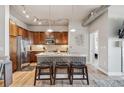 Stylish kitchen with a stainless steel refrigerator, wooden cabinets, and a center island with decorative front panels at 10111 Inverness Main St # 230, Englewood, CO 80112