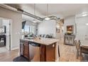 Modern kitchen island featuring granite countertops, stainless steel appliances, wooden cabinets, and hardwood floors at 10111 Inverness Main St # 230, Englewood, CO 80112