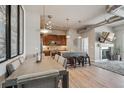 Open-concept living area with modern lighting fixtures, wood floors, fireplace and adjacent kitchen with bar seating at 10111 Inverness Main St # 230, Englewood, CO 80112