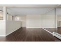 Living room with dark laminate floors and mirrored accent wall at 310 S Ames St # 11, Lakewood, CO 80226