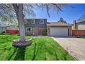 Charming two-story home with a well-manicured lawn, brick accents and a two car garage on a sunny day at 6527 S Yarrow Way, Littleton, CO 80123