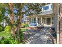 Inviting front porch with seating area and beautifully landscaped yard with mature trees in front of the home at 2742 S Braun Way, Lakewood, CO 80228