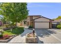 Charming two-story home with a lush front yard, brick accents, and a two-car garage at 3870 S Ouray Way, Aurora, CO 80013