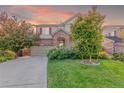 Charming two-story home featuring a brick entryway, attached garage, and mature landscaping in a suburban neighborhood at 129 N Irvington St, Aurora, CO 80018