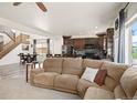 Open-concept layout with a large sectional sofa, connecting the living area to the kitchen and stairs at 3834 Donnington Cir, Castle Rock, CO 80104