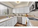 Bright kitchen featuring white cabinets, stainless steel appliances, and a large window for natural light at 266 S Nome St, Aurora, CO 80012