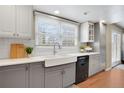 Bright and airy kitchen featuring a farmhouse sink, white subway tile, and sleek black appliances at 16750 E Prentice Ave, Centennial, CO 80015