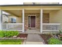 Charming covered front porch with white columns, brick accents and a cozy seating area at 154 Falcon Cir, Mead, CO 80542