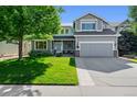 Charming two-story home boasts a manicured lawn, a two-car garage and inviting front porch with beautiful curb appeal at 4814 S Upham Ct, Littleton, CO 80123