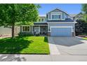 Charming two-story home featuring a well-manicured lawn, an attached two-car garage, and a welcoming front porch at 4814 S Upham Ct, Littleton, CO 80123