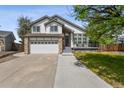 Charming two-story home featuring a stone facade, attached two-car garage, and inviting front porch at 19131 E Garden Pl, Centennial, CO 80015