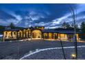 Stunning modern home with stone accents, large windows, and meticulous landscaping, set against a dramatic sky at 21429 Trappers Trl, Morrison, CO 80465