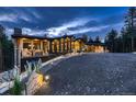 Gorgeous exterior view with stunning architecture and beautiful landscaping at twilight at 21429 Trappers Trl, Morrison, CO 80465