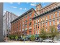 Exterior view of brick apartment building in city with street and sidewalk at 1555 California St # 419, Denver, CO 80202