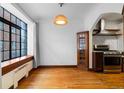 Dining room featuring large window, hardwood floors, decorative corner cabinet, and convenient access to kitchen at 1060 N Washington St # 103, Denver, CO 80203