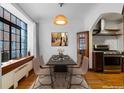 Charming dining room featuring hardwood floors, a modern light fixture, and a view of the kitchen at 1060 N Washington St # 103, Denver, CO 80203