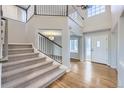 Bright foyer featuring hardwood floors, a staircase with white railings, and a view into the living spaces at 6493 W 98Th Ct, Westminster, CO 80021