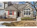 House exterior with stone, red shutters, and landscaping at 6415 Trailhead Rd, Highlands Ranch, CO 80130